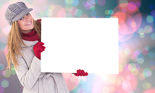 유토이미지 Composite image of happy blonde in winter clothes showing card