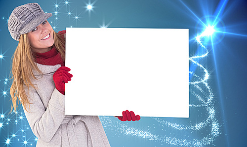 유토이미지 Composite image of happy blonde in winter clothes showing card