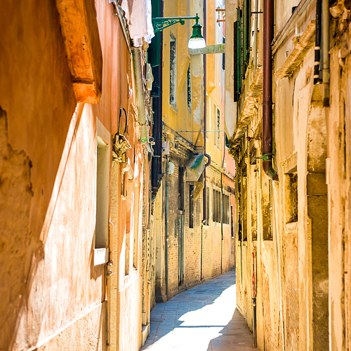 유토이미지 Old narrow street with brick houses in Venice Italy