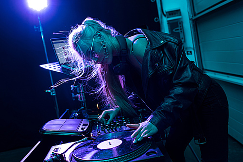 유토이미지 attractive blonde dj girl touching vinyl record in nightclub