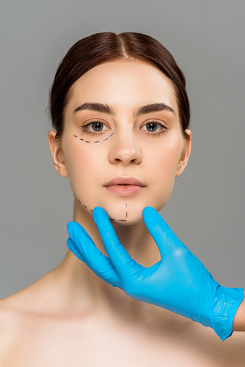 유토이미지 cropped view of plastic surgeon in latex glove touching face of