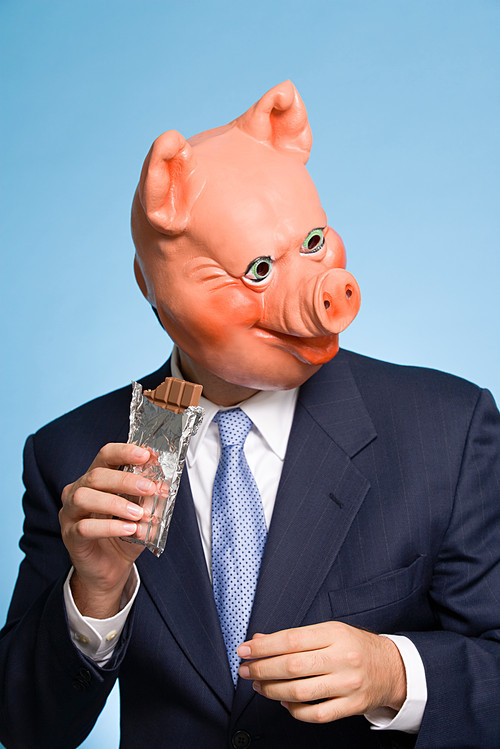Man in a pig mask eating chocolate