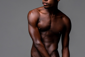 Nude lean young African man body in studio isolated gray background