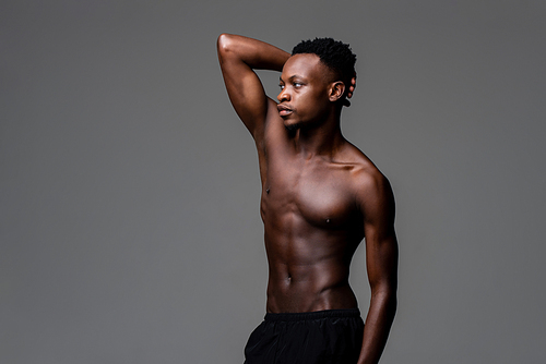 Shirtless African man posing with one arm up isolated gray on studio background