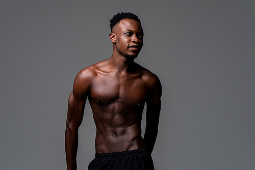 Shirtless young lean fit African man in isolated light gray background