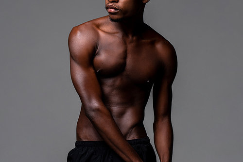 Nude lean young African man body in studio isolated gray background