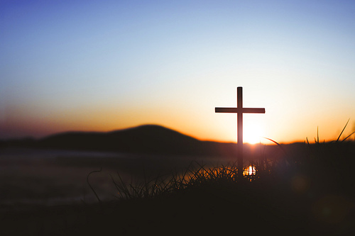 노을 하늘 강한 빛과 풀밭위에예수 그리스도의 거룩한 십자가는 죽음과 부활 사랑을 상징합니다.
