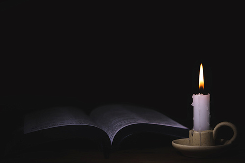 촛대위에 밝게 타오르는 촛불과 거룩한 성경책 그리고 예배와 묵상과 기도 예수그리스도의 말씀