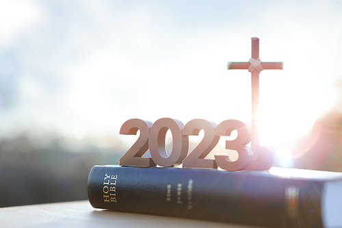 2023년 새해 떠오르는 태양과 일출 그리고 예수 그리스도의 십자가와 거룩한 성경책