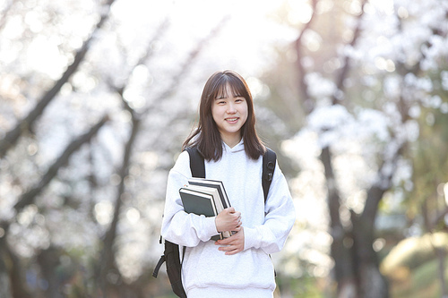 입학의 계절 봄 학교 벚꽃 나무 앞에서 행복한 표정으로 환하게 웃고있는 여자 고등학생과 대학생 컨셉