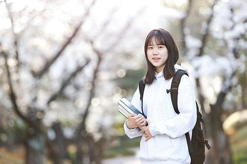 입학의 계절 봄 학교 벚꽃 나무 앞에서 행복한 표정으로 환하게 웃고있는 여자 고등학생과 대학생 컨셉
