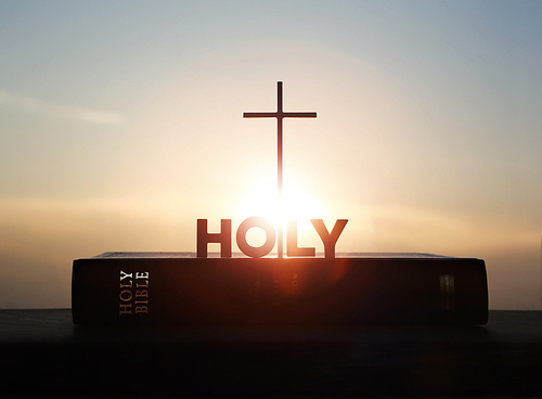 밝게 떠오르는 태양 새해 일출과 예수그리스도의 거룩한 십자가와 성경책 그리고 HOLY 텍스트