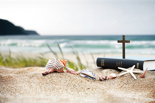파도치는 바다와 모래 해변위에 성경책과 예수 그리스도의 십자가 그리고 조개와 소라와 불가사리가 있는 교회 여름 수련회 컨셉 여름성경학교 여름 캠프 배경