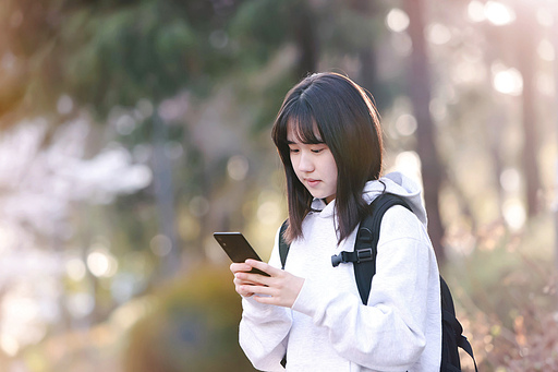 스마트폰으로 게임을 하고 친구와 SNS 문자를 주고 받는 여자 고등학생과 대학생 여행 컨셉