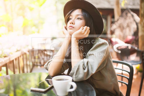 Woman drinking coffee in the garden outdoor in sunlight light en