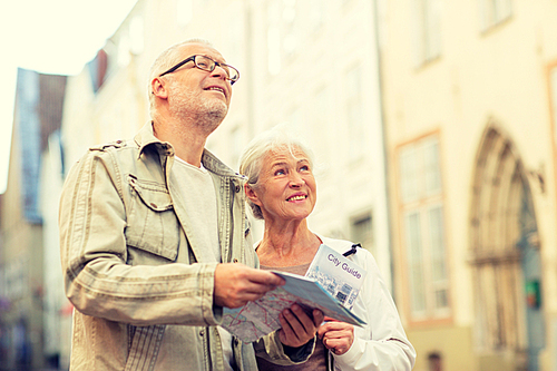 family, age, tourism, travel and people concept - senior couple with map and city guide on street