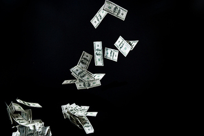 business, finance, waste and concept - close up of us dollar money flying over black background
