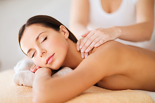 beauty, spa, resort and relaxation concept - beautiful woman in spa salon getting massage