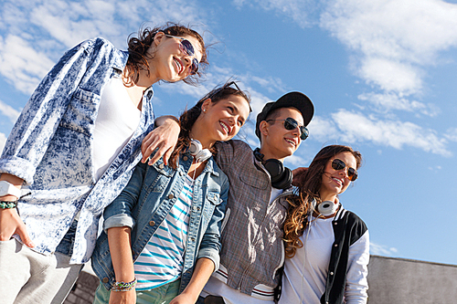 summer holidays and teenage concept - group of smiling teenagers in sunglasses hanging outside