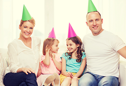 celebration, family, holidays, children and birthday concept - happy family with two chldren in hats celebrating