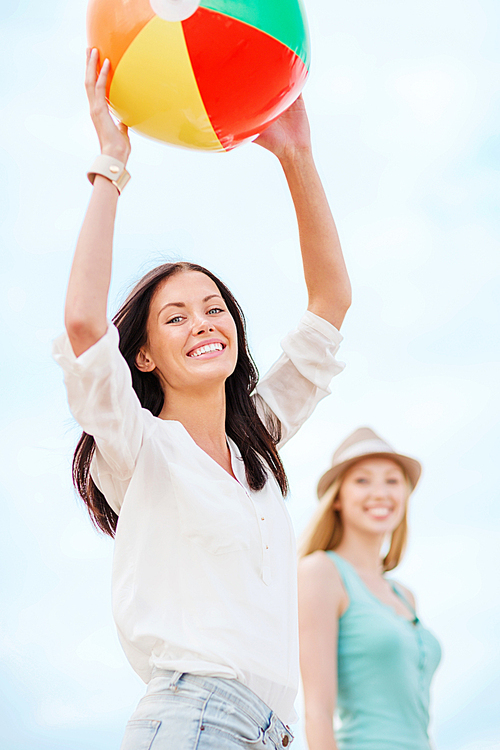 summer holidays, vacation and beach activities - girls playing ball on the beach