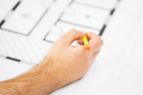 building, architecture, construction and people concept - close up of male hand with blueprint and pencil