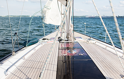 vacation, travel, cruise and leisure concept - close up of sailboat or sailing yacht deck and sea