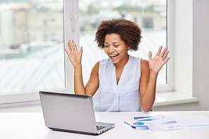 education, business, success and technology concept - happy african american businesswoman or student with laptop computer and papers at office