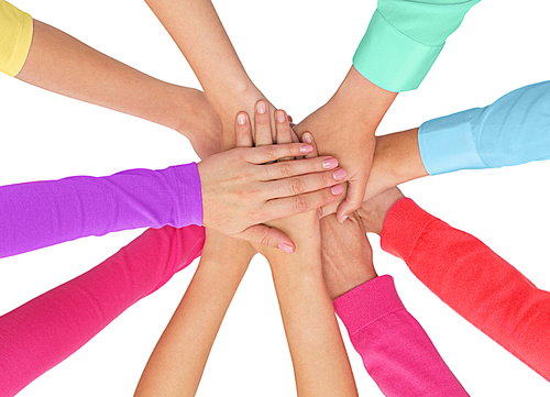 people, gesture, gay pride and homosexual concept - close up of women hands in rainbow clothes on top of each other over white background