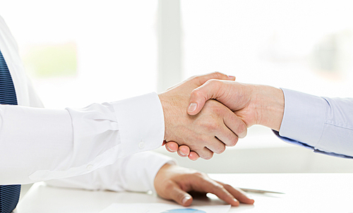 business, people, partnership, gesture and cooperation concept - close up of hands making handshake in office