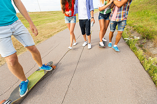people, leisure and sport concept - close up of teenage friends with longboards and drinks outdoors