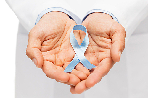 healthcare, profession, people and medicine concept - close up of male doctor hands holding sky blue prostate cancer awareness ribbon