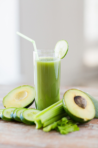 healthy eating, organic food and diet concept - close up of fresh green juice glass and vegetables on table