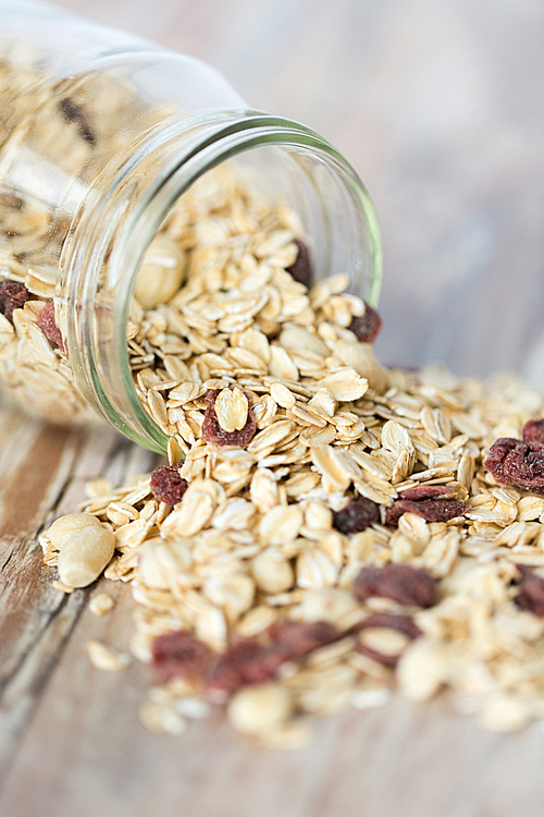 food, healthy eating and diet concept - close up of jar with granola or muesli on table