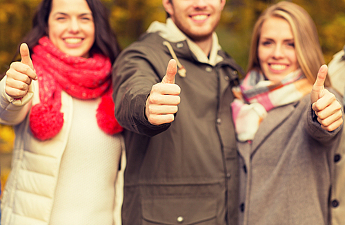 friendship, gesture, season and people concept - close up of happy friends showing thumbs up in autumn park