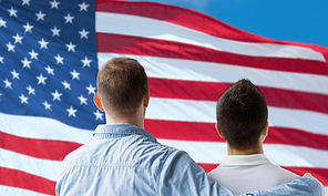 people, homosexuality, same-sex marriage, gay and love concept - close up of happy male gay couple or friends hugging from back over american flag background