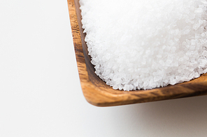 food, junk-food, cooking and unhealthy eating concept - close up of white sea salt heap in wooden bowl