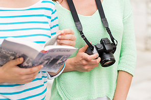 tourism, travel, leisure and friendship concept - close up of women with city guide and camera outdoors