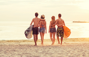 friendship, sea, summer vacation, water sport and people concept - group of smiling friends wearing swimwear with surfboards on beach from back