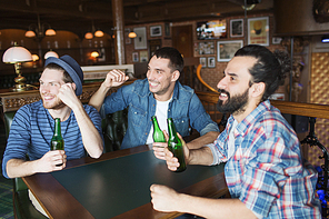 people, leisure, friendship and bachelor party concept - happy male friends drinking bottled beer and raised hands rooting for football match at bar or pub