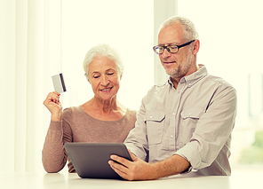 family, technology, age and people concept - happy senior couple with tablet pc computer and credit card at home