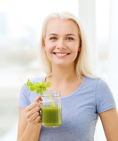healthy eating, vegetarian food, dieting, detox and people concept - smiling woman drinking green vegetable juice or shake from glass at home
