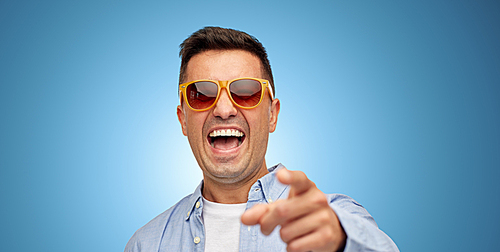 summer, style, emotions and people concept - face of laughing middle aged latin man in shirt and sunglasses over blue background