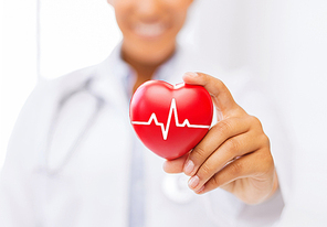 healthcare and medicine concept - female african american doctor holding red heart with ecg line
