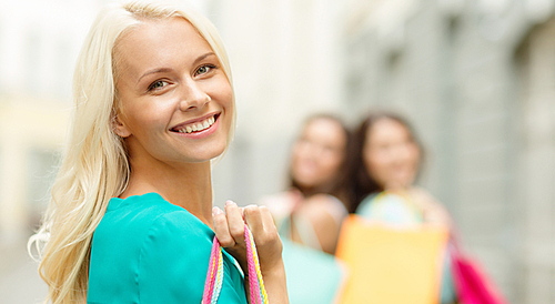 sale, shopping, tourism and happy people concept - beautiful woman with shopping bags in the ctiy