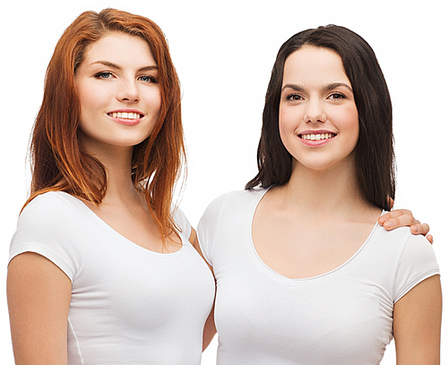 friendship, t-shirt designe and happy people concept - two laughing girls in white blank t-shirts hugging