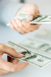 business, finance, saving, banking and people concept - close up of woman hands counting us dollar money