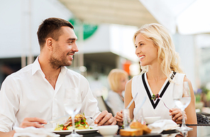 love, date, people, holidays and relations concept - happy couple eating salad for dinner at cafe or restaurant terrace