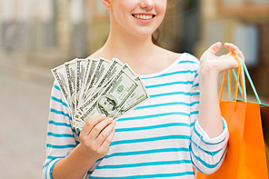 tourism, travel, sale and consumerism concept - close up of happy woman with shopping bags and dollar money on city street
