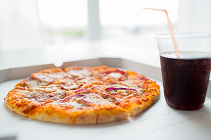 fast food, italian kitchen and eating concept - close up of pizza in paper box with cup of cola drink on table
